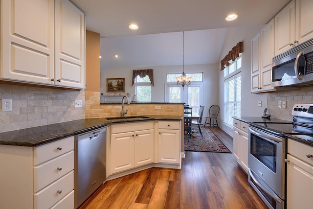 kitchen with sink, stainless steel appliances, white cabinetry, and pendant lighting