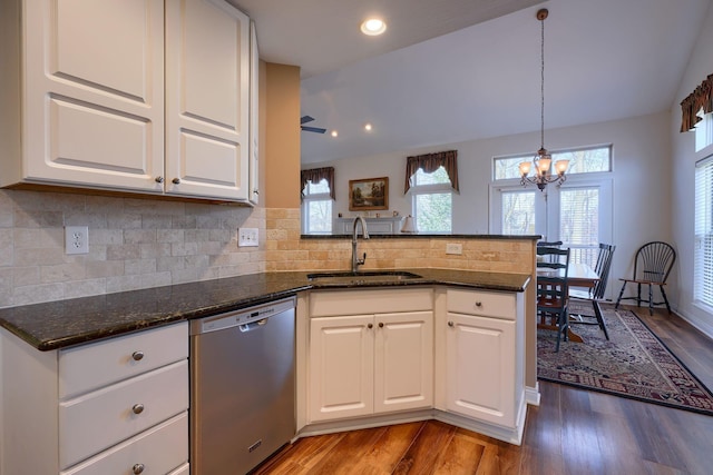 kitchen with white cabinetry, sink, stainless steel dishwasher, and dark stone countertops