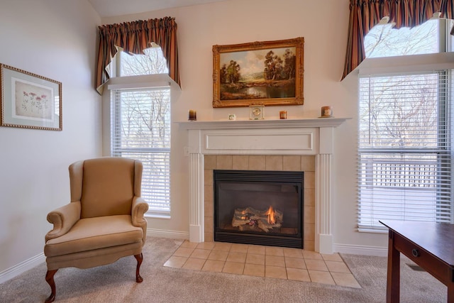 sitting room with carpet, a tiled fireplace, and plenty of natural light