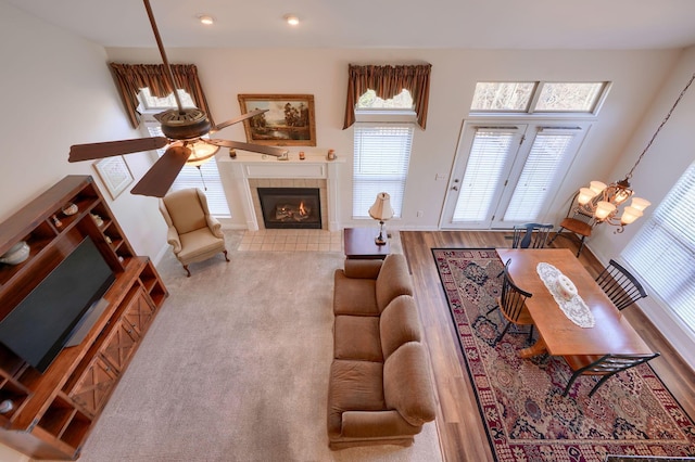 living room with a tiled fireplace and ceiling fan