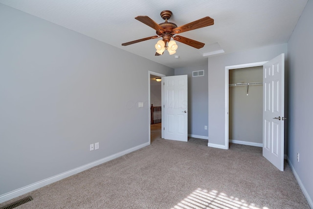 unfurnished bedroom with ceiling fan, light carpet, and a closet