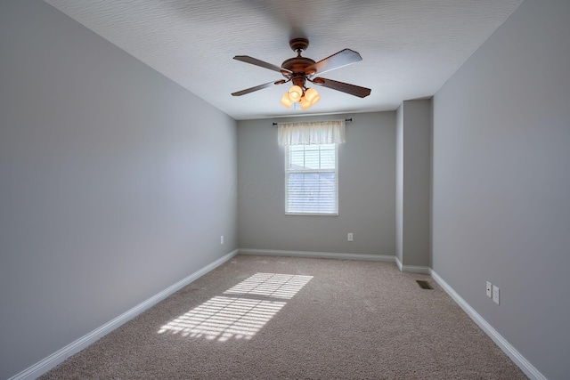 carpeted spare room featuring ceiling fan and a textured ceiling