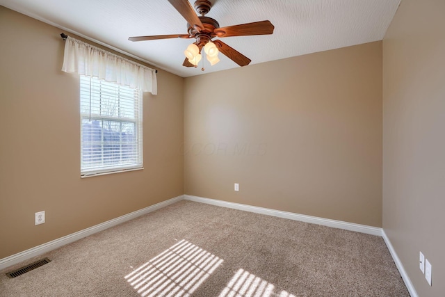 carpeted spare room featuring ceiling fan