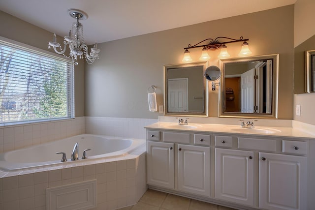 bathroom featuring tiled bath, tile patterned floors, a chandelier, and vanity