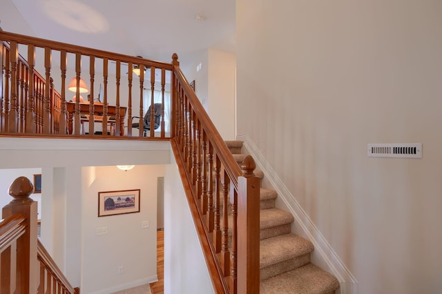 stairway featuring a towering ceiling