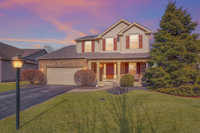 view of front of property featuring a garage and a lawn