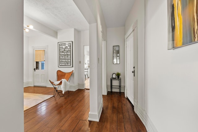 corridor featuring a textured ceiling and dark hardwood / wood-style floors