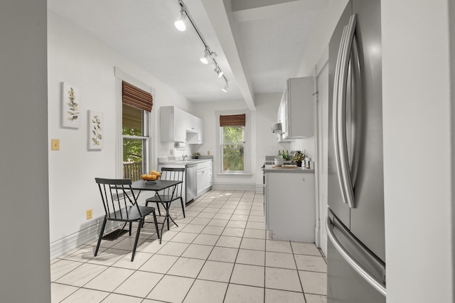 kitchen featuring white cabinets, track lighting, light tile patterned floors, and appliances with stainless steel finishes