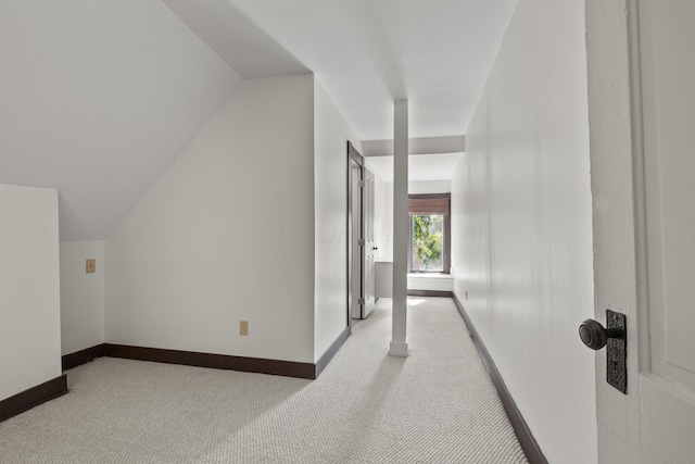 interior space featuring light carpet and vaulted ceiling