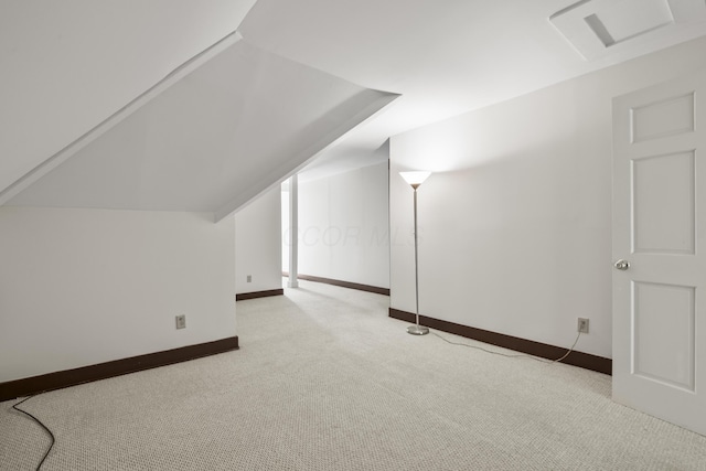 additional living space featuring light colored carpet and lofted ceiling