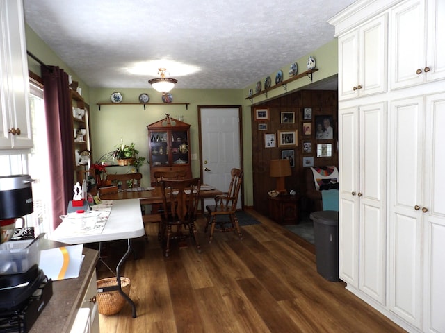 dining area with dark wood-type flooring and a textured ceiling