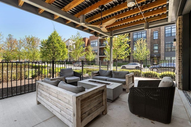 view of patio with fence, an outdoor living space with a fire pit, and ceiling fan