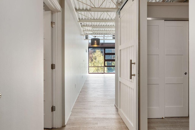 corridor with light wood-style floors and baseboards