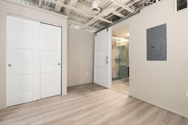 unfurnished bedroom featuring visible vents, a closet, light wood-style floors, electric panel, and ensuite bath