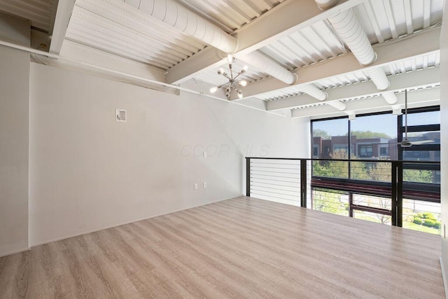 spare room with wood finished floors, a chandelier, and beamed ceiling