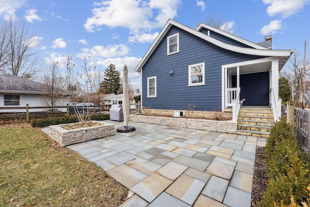 back of property featuring a patio, a chimney, and fence