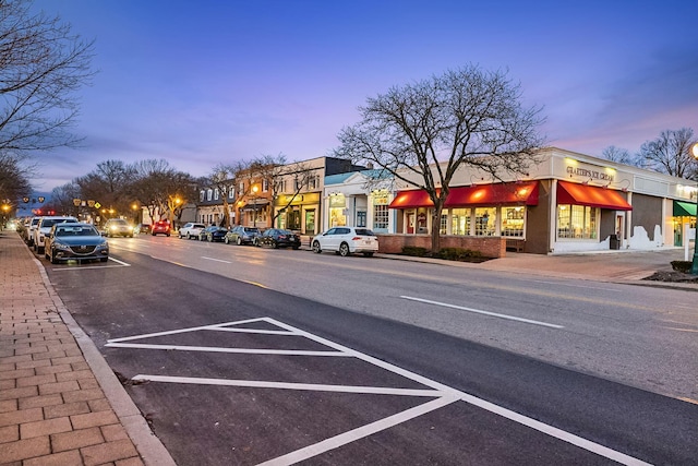 view of street featuring sidewalks, traffic lights, street lighting, and curbs