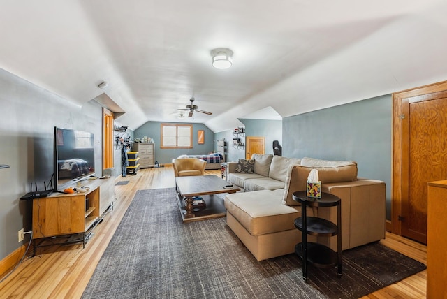 living room featuring baseboards, a ceiling fan, vaulted ceiling, and wood finished floors