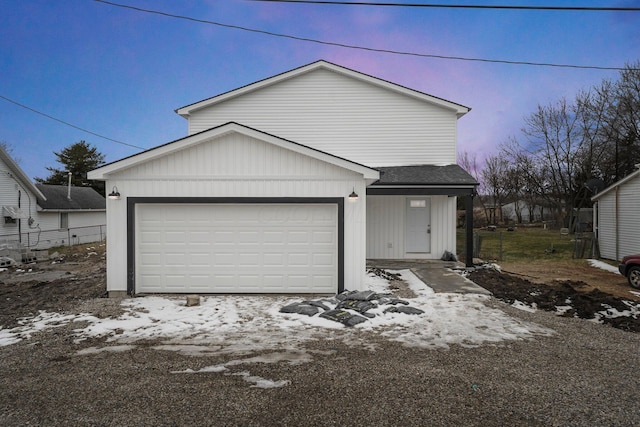 view of front of house with a garage and roof with shingles