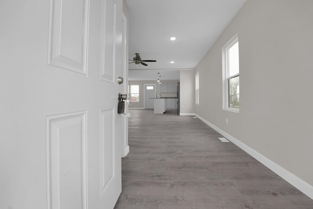 hallway featuring recessed lighting, baseboards, and wood finished floors