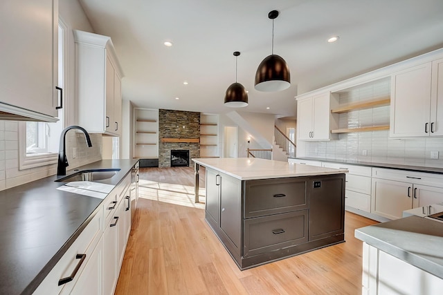 kitchen featuring hanging light fixtures, white cabinetry, gray cabinets, and a sink