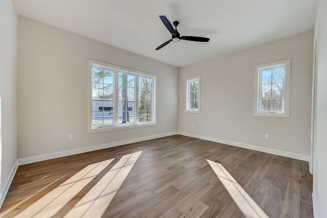 empty room featuring ceiling fan, light wood-type flooring, and baseboards