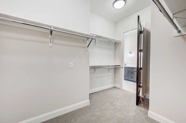 walk in closet featuring light carpet