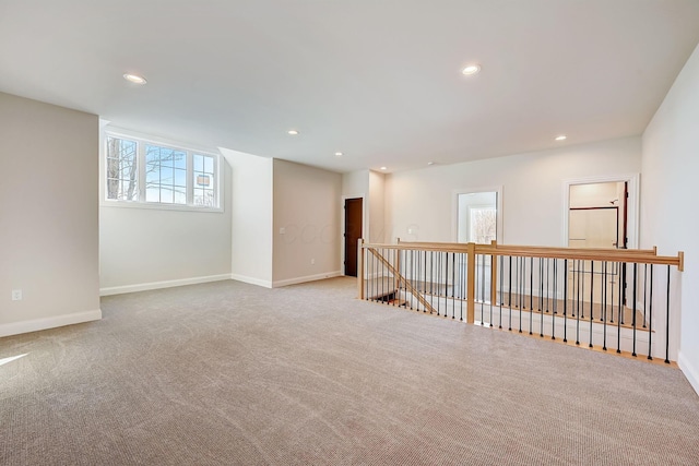 spare room featuring baseboards, light carpet, and recessed lighting