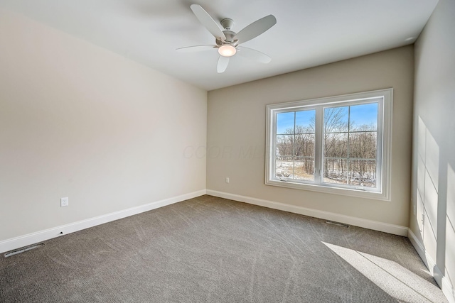 carpeted empty room with visible vents, baseboards, and a ceiling fan