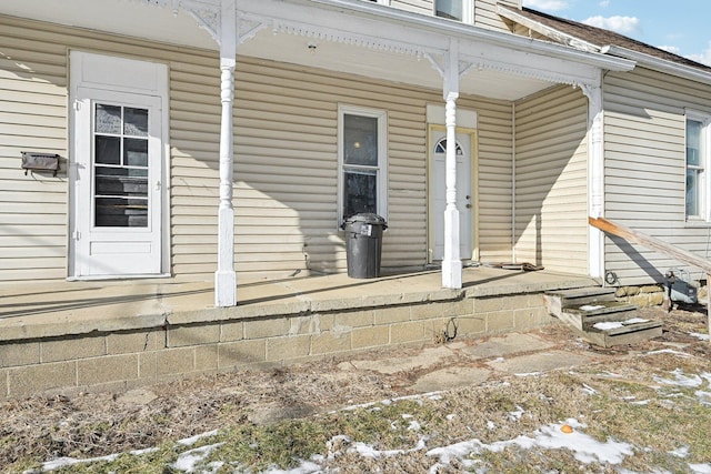 snow covered property entrance featuring covered porch