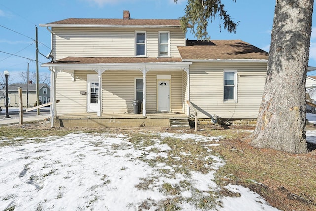 view of front of home with a porch and a chimney