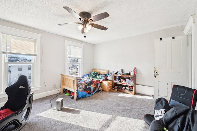 carpeted bedroom featuring baseboards, ceiling fan, and a textured ceiling