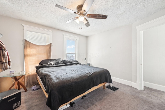 carpeted bedroom with baseboards, visible vents, ceiling fan, and a textured ceiling