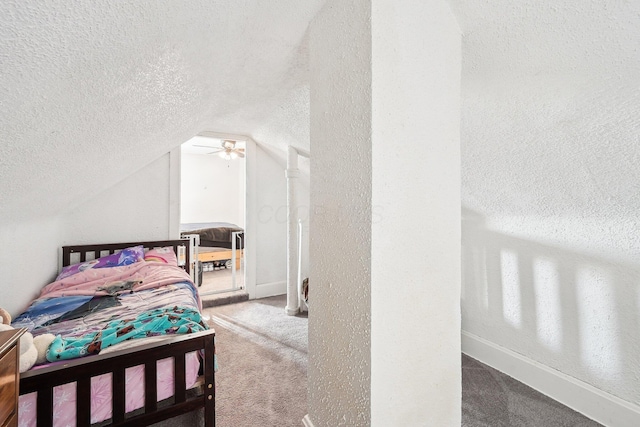 bedroom featuring lofted ceiling, carpet flooring, baseboards, and a textured ceiling