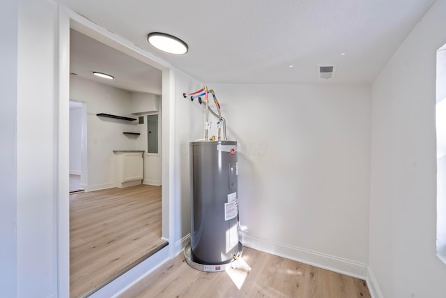 utility room featuring visible vents and electric water heater