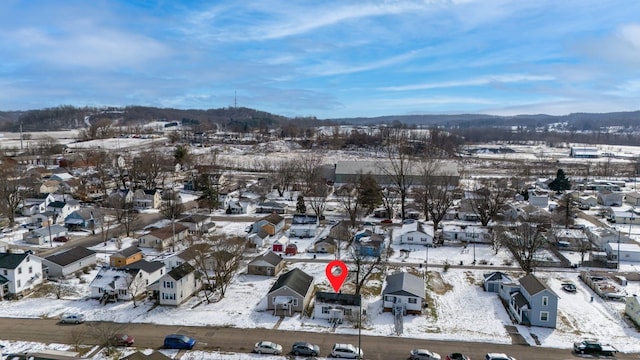 snowy aerial view featuring a residential view and a mountain view