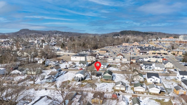 snowy aerial view featuring a residential view and a mountain view