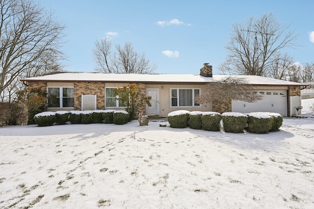 ranch-style house featuring brick siding, a chimney, and an attached garage