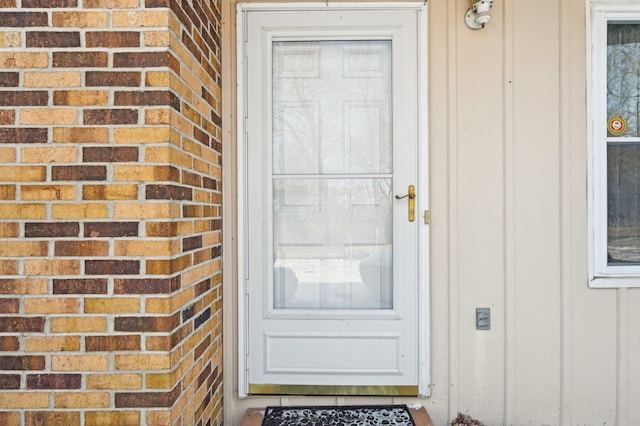 doorway to property with brick siding