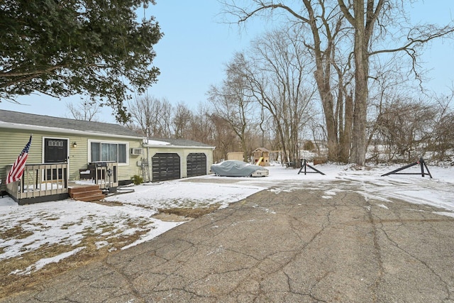 yard layered in snow with driveway and a garage