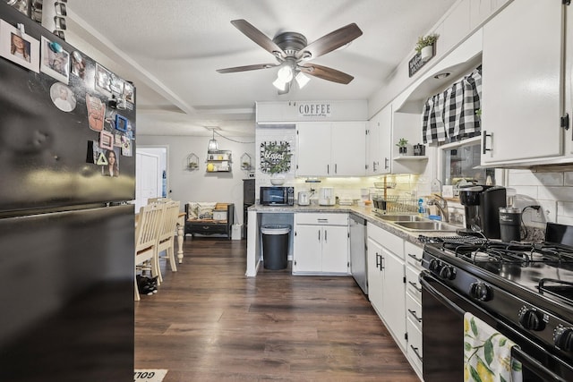 kitchen with a sink, dark wood-type flooring, backsplash, black appliances, and white cabinets