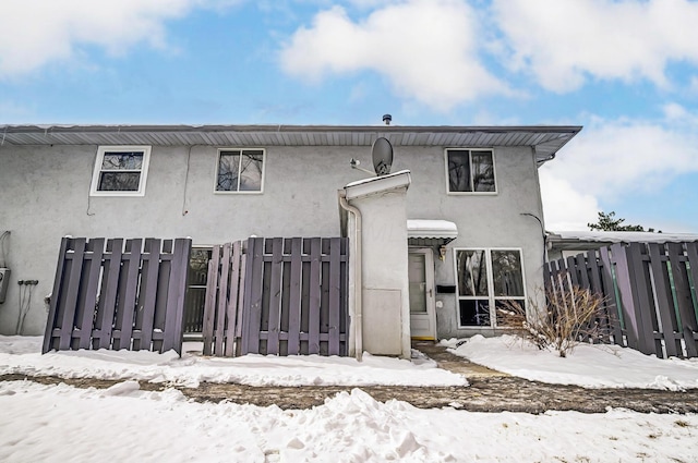 view of front facade featuring fence and stucco siding