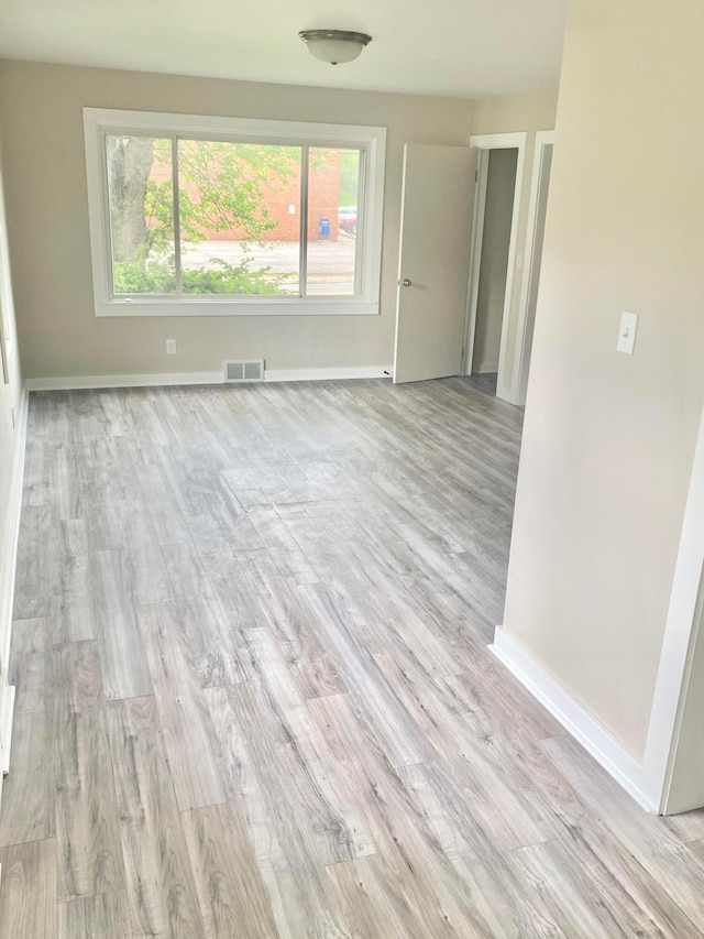 interior space with light wood-style flooring, visible vents, and baseboards