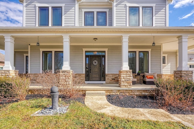 entrance to property featuring stone siding and a porch