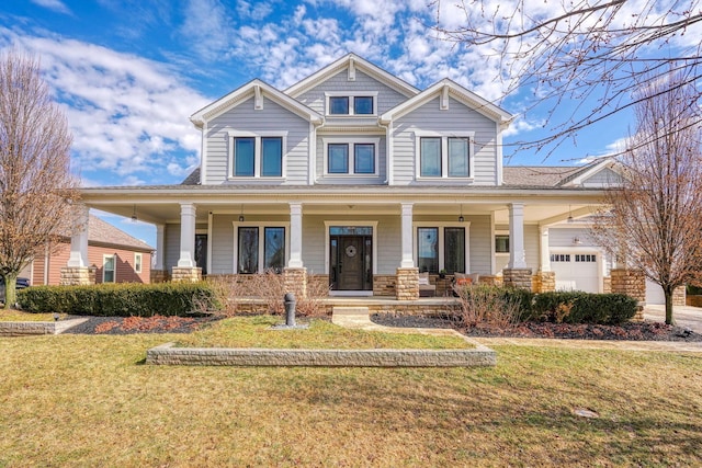 craftsman house with an attached garage, covered porch, stone siding, and a front yard