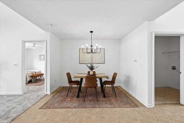 carpeted dining area featuring a chandelier, tile patterned floors, and baseboards