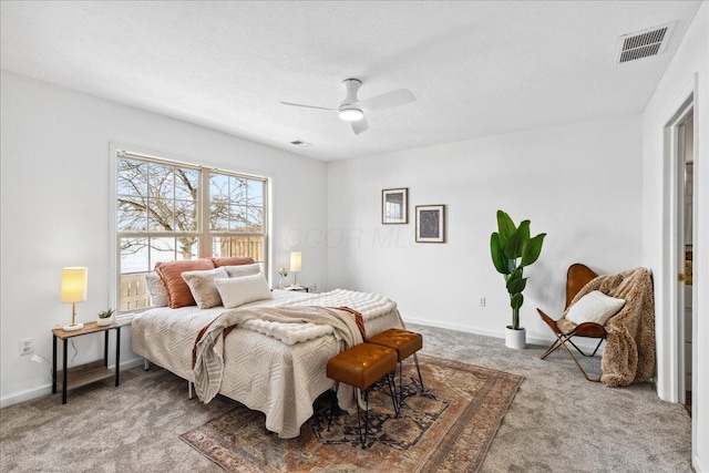 bedroom featuring baseboards, visible vents, a ceiling fan, a textured ceiling, and carpet floors