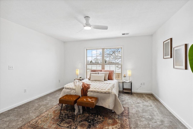 carpeted bedroom with a ceiling fan, visible vents, a textured ceiling, and baseboards