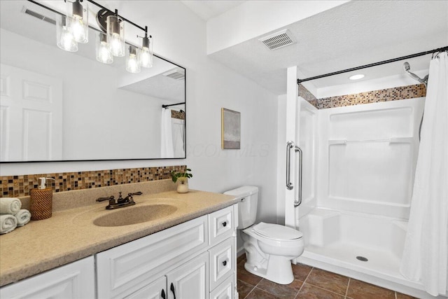 bathroom featuring toilet, a stall shower, visible vents, and vanity