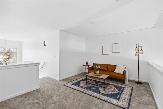 living room featuring baseboards, a chandelier, and light colored carpet